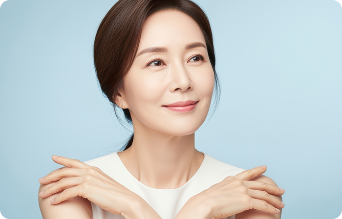 양어깨에 손을 올리고 옆을 바라보는 중년 여성 모델
