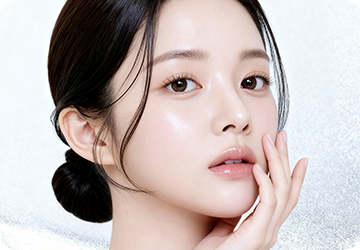 손끝을 볼에 댄 채 정면을 바라보는 여성 모델