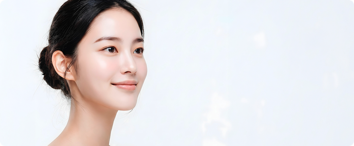 흰 배경에서 옆을 바라보며 미소 짓는 여성 모델의 상반신